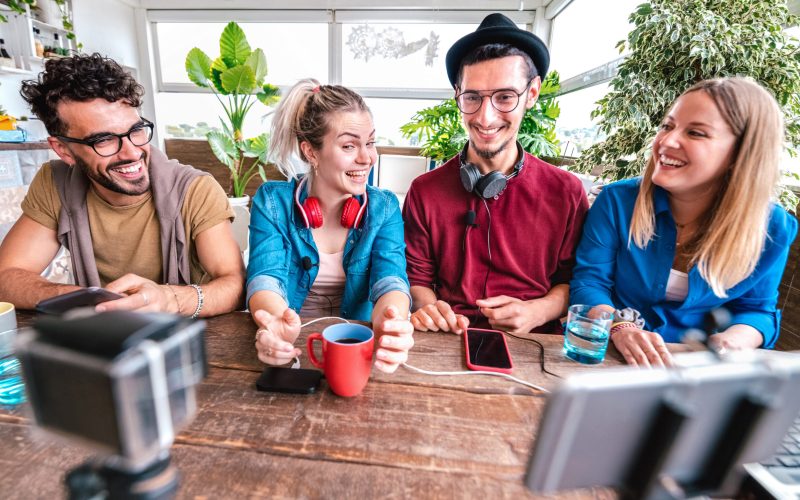 Digital native friends sharing video on streaming platform with web phone camera - Content marketing concept with millenial students having fun vlogging live feeds on social media space - Vivid filter