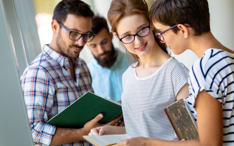 Education campus friendship people concept. Group of happy students learning together in college library