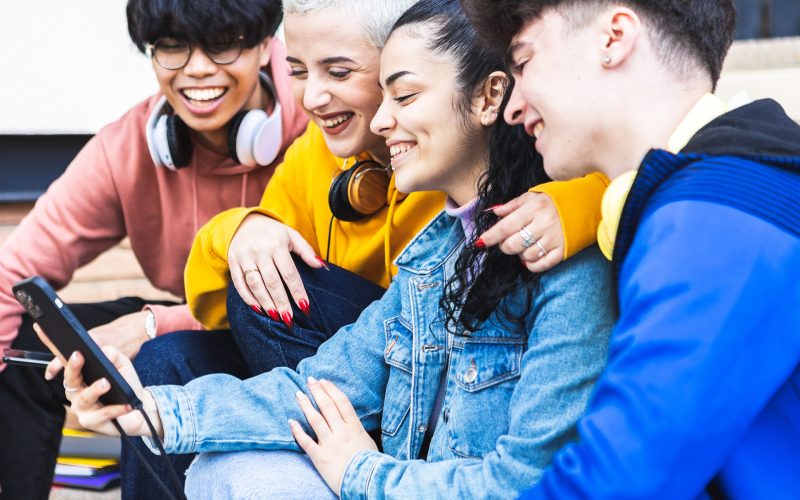 smiling-friends-looking-at-phone-in-urban-setting-2026-01-09-07-18-31-utc