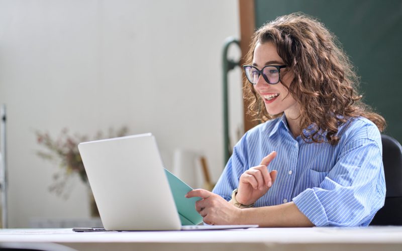 Young business woman leading hybrid online remote video call working in office.